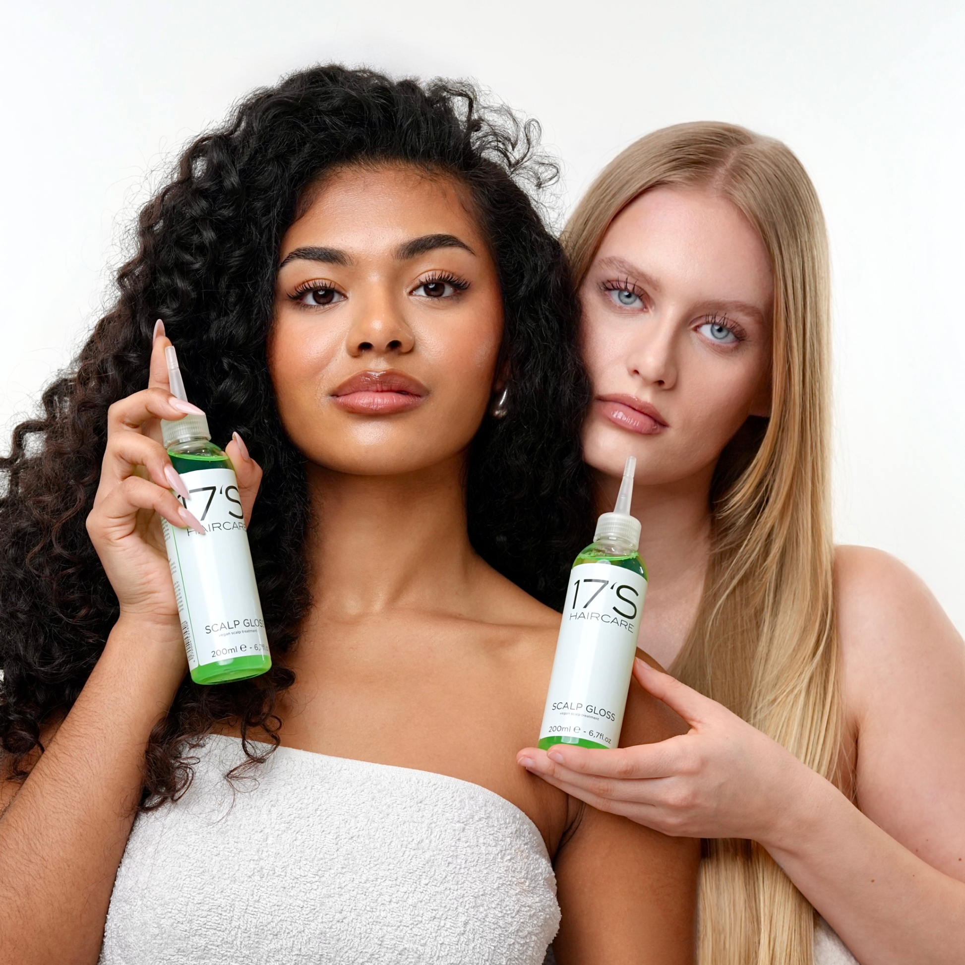 Two models with curly and straight hair holding 17's Haircare Scalp Gloss for a healthy scalp routine