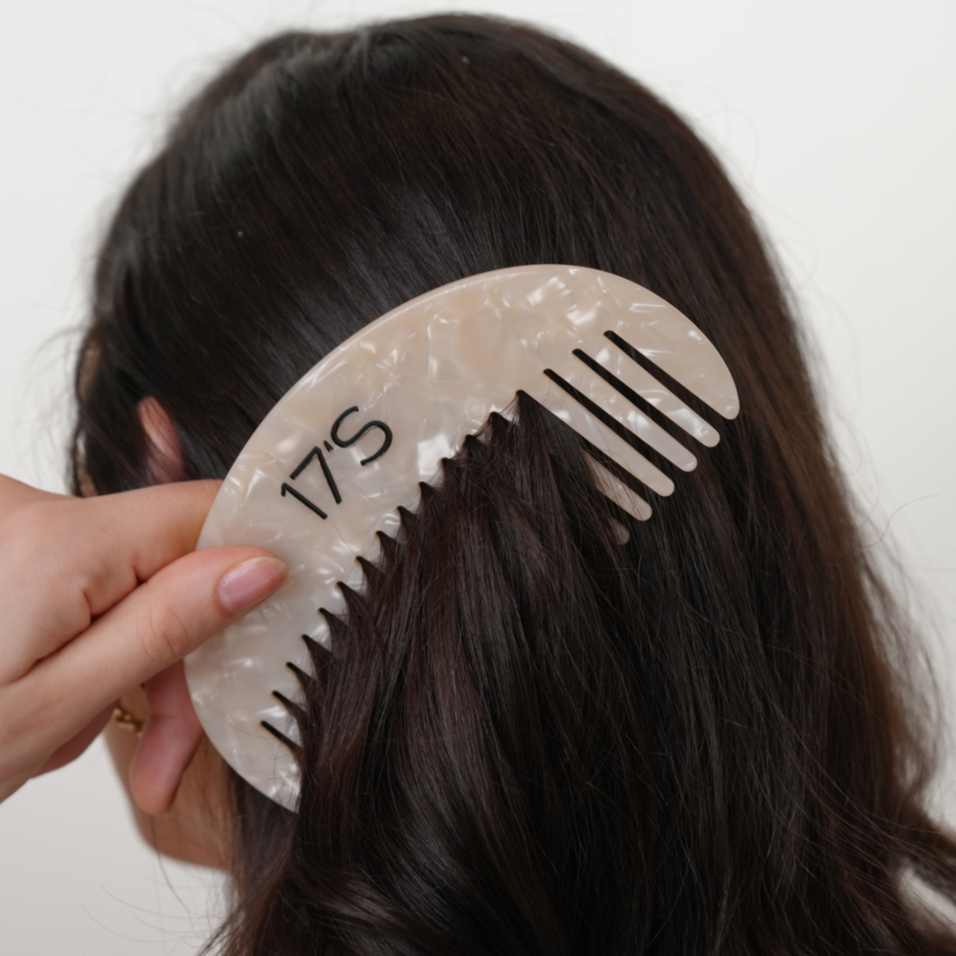 17's Haircare Vanilla Pearl Comb wide tooth comb gliding through dark hair for gentle detangling